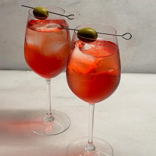 Two red spritz with olives